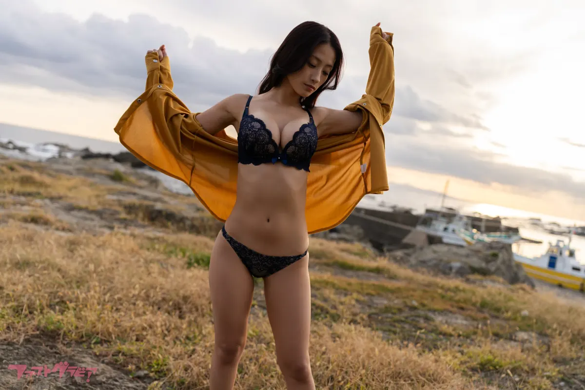 Ayano Sumida (澄田綾乃) outdoors in coastal light holding a yellow jacket. SOLARIA (digital photobook) coverage.