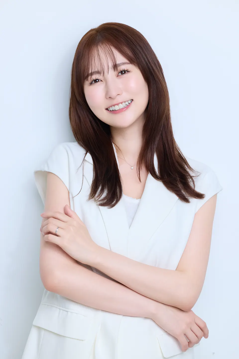 Rina Matsuki (まつきりな) smiling with her arms folded, wearing white against a pale blue background.