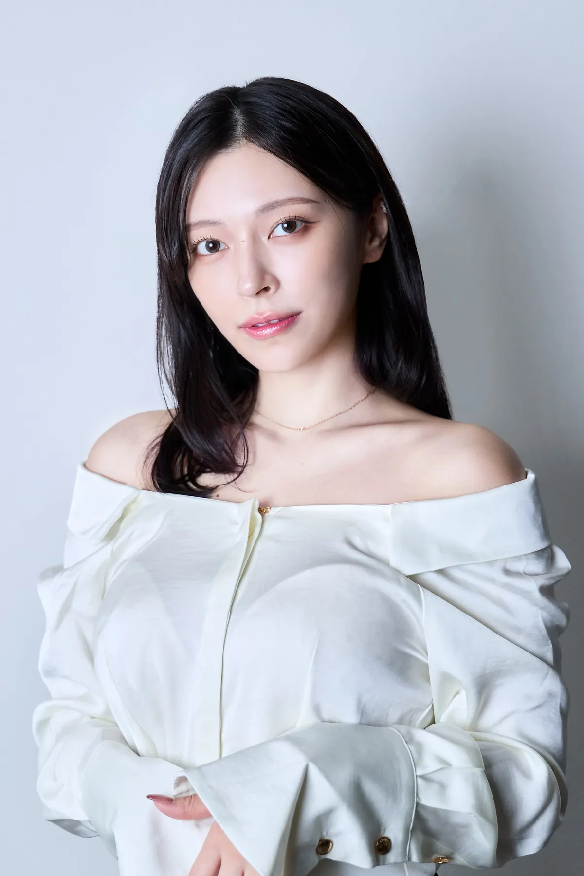 minahebi (みなへび) wearing a white off-the-shoulder blouse against a pale gray background.