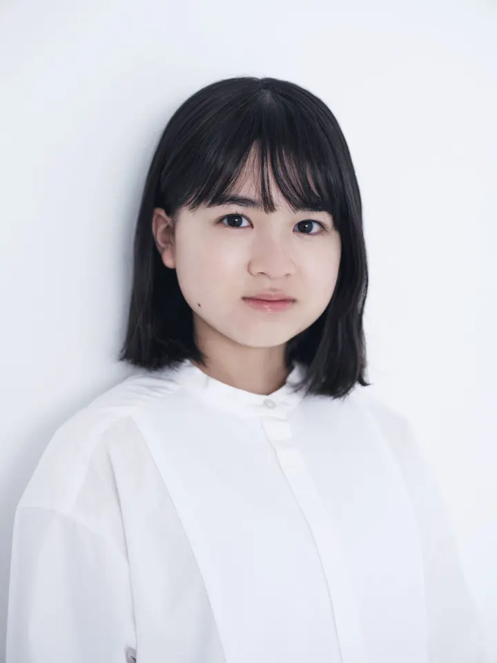 Chise Niitsu wearing a white blouse against a pale background.
