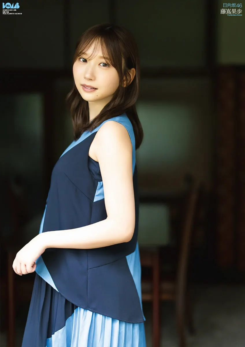 The other side of the BOMB November 2026 regular-edition poster, showing Kaho Fujishima (藤嶌果歩) standing indoors in a sleeveless navy and light-blue dress.
