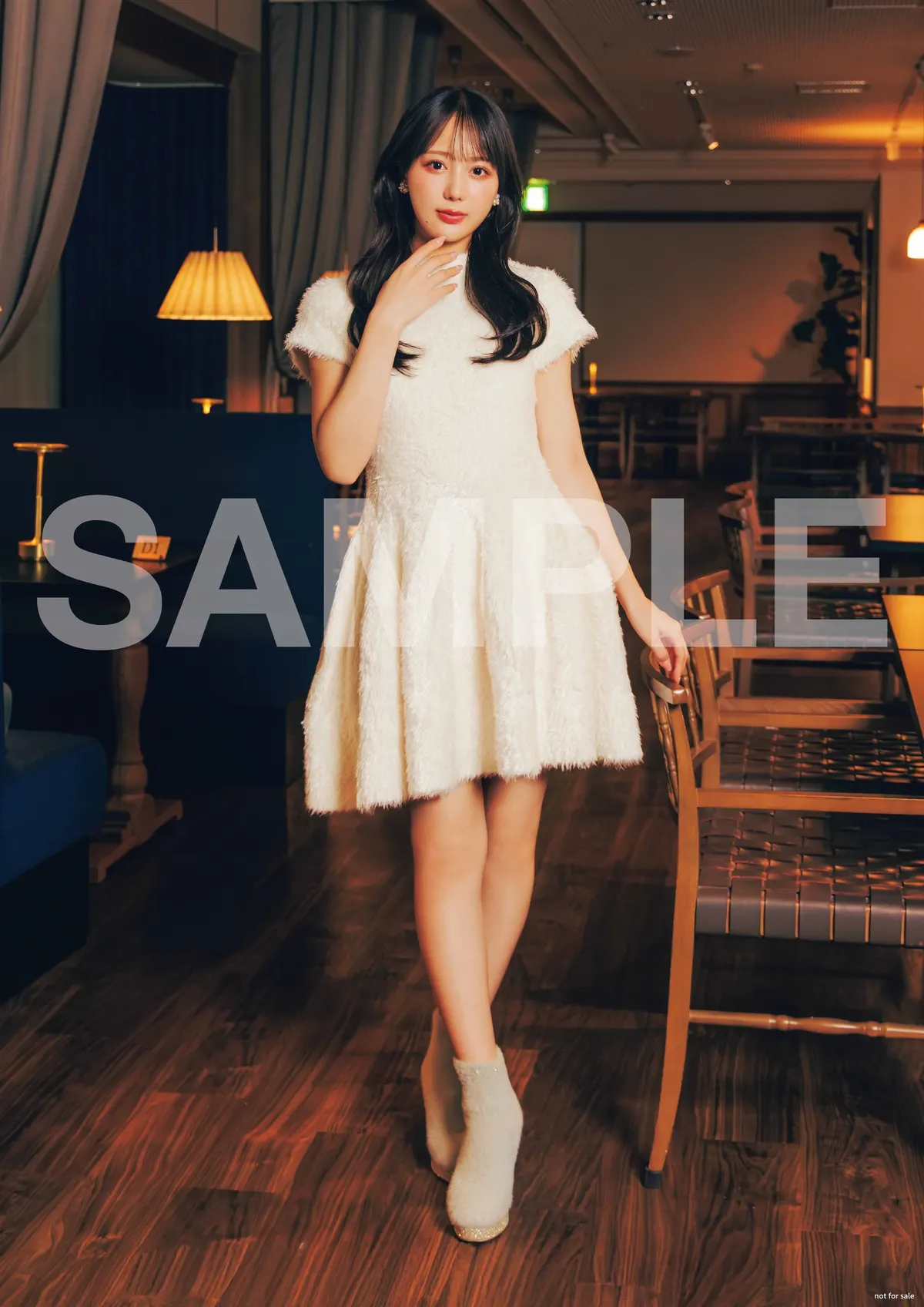 Mao Asaoka in a textured white dress and light-colored ankle boots beside wooden chairs and warm lamps, with a large SAMPLE watermark.