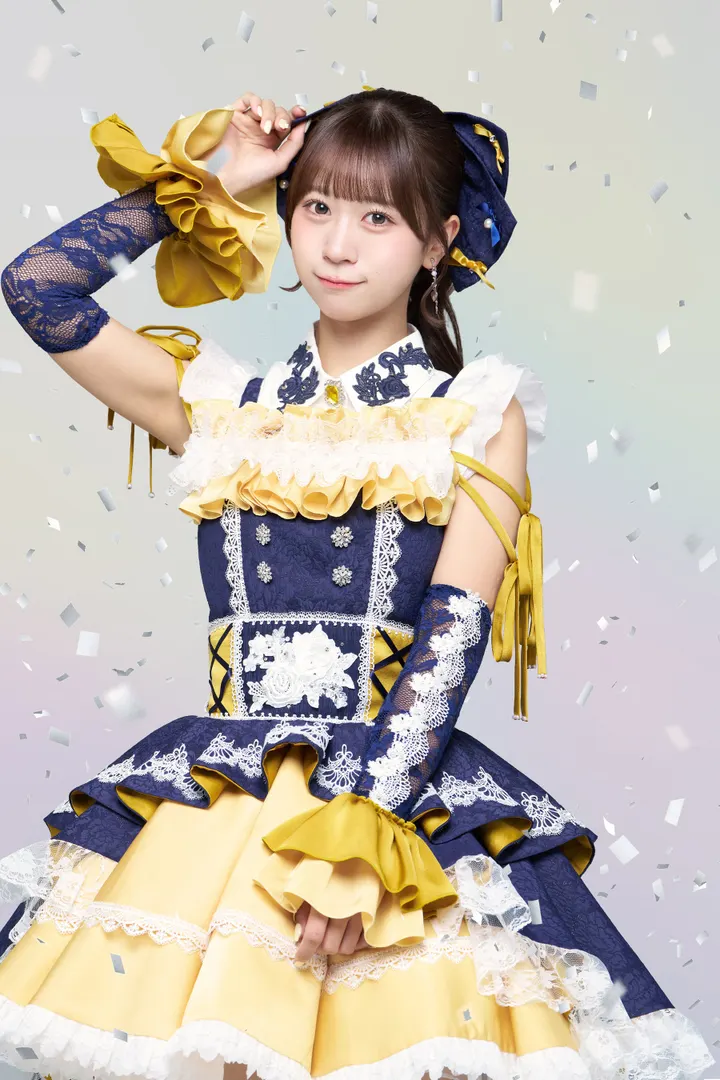 Arisa Takanashi poses with one hand beside her head in a navy, white and yellow ruffled stage costume.