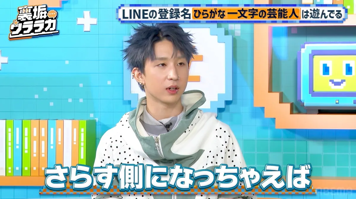 A guest with blue-gray hair and facial jewelry wears a white dotted outer layer with a pale-green collar, against a turquoise studio backdrop with Japanese captions.