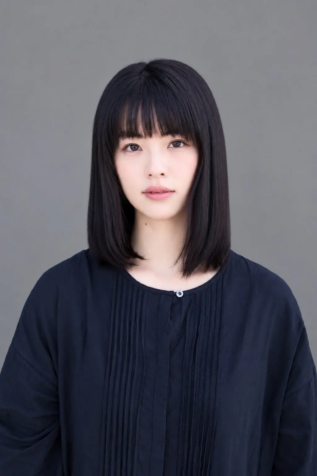 Urara Matsubayashi wears a dark blouse against a gray background.