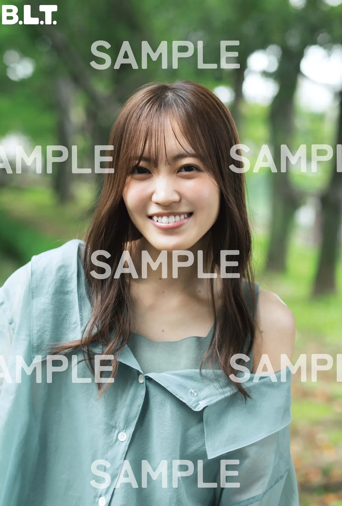 SAMPLE-marked HMV Rina Matsuda postcard, showing her smiling outdoors in blue-green layers against greenery.