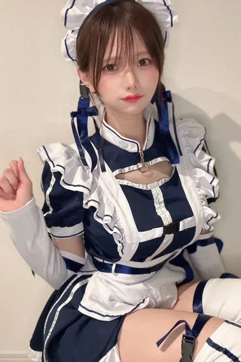 Publicity portrait of Naho Shinomiya seated in a navy-and-white maid-style costume with a ruffled headpiece and blue ribbons.