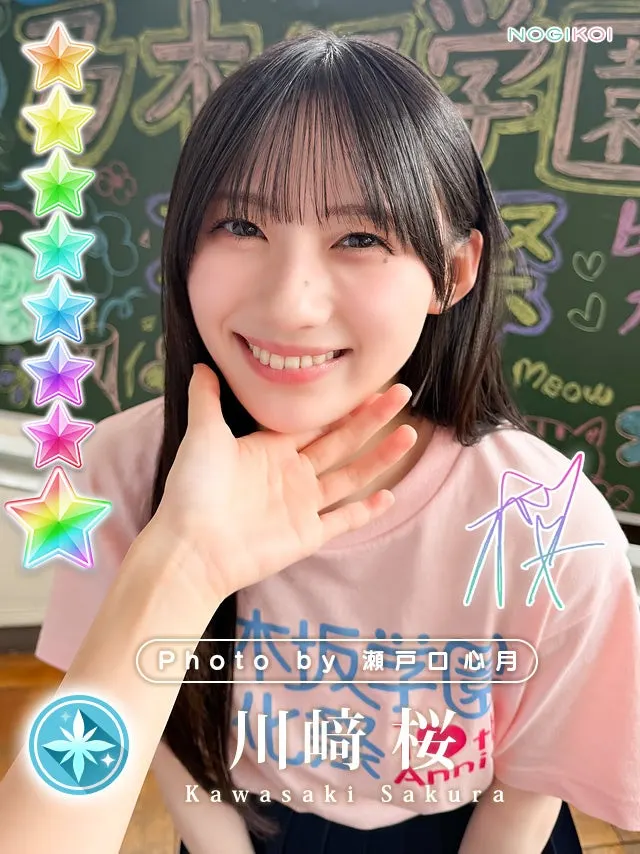 Sakura Kawasaki smiles with a hand beneath her chin in front of a chalkboard on a Nogikoi digital card photographed by Mitsuki Setoguchi.