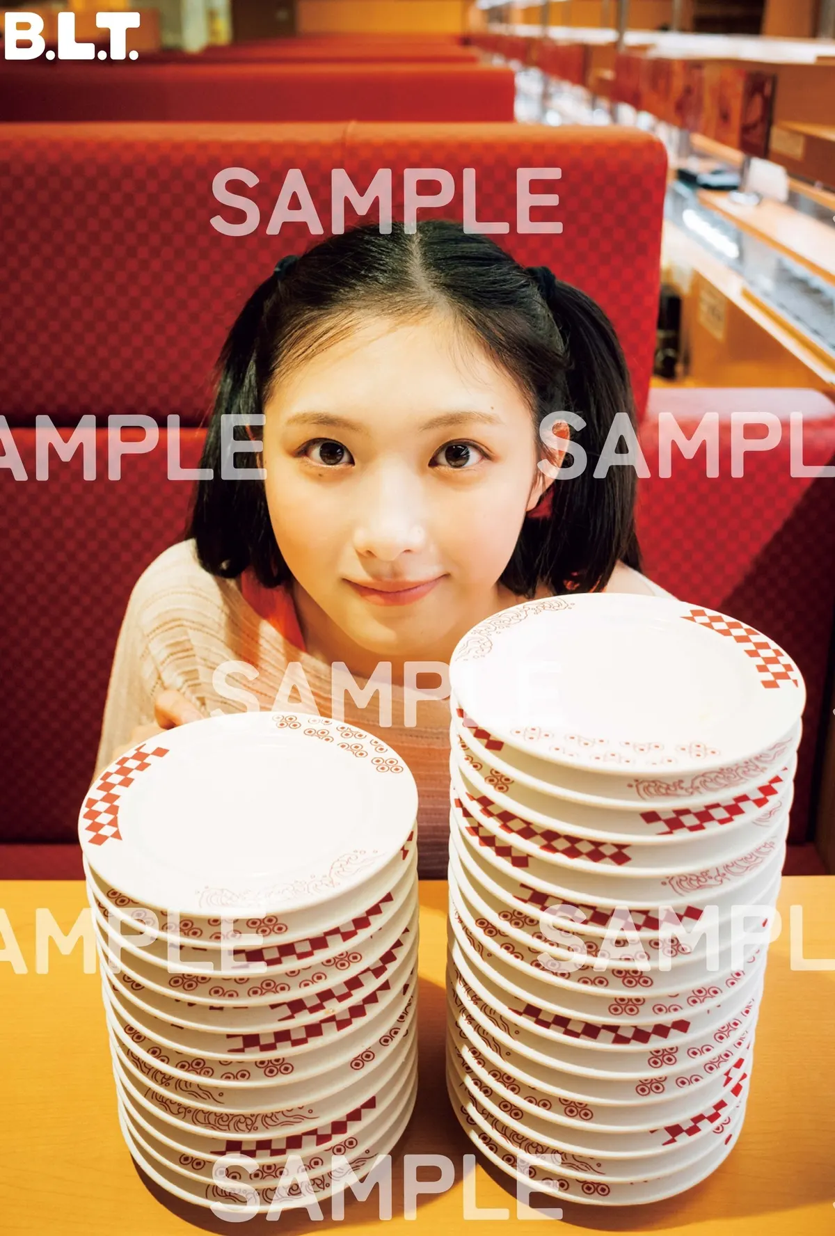 SAMPLE-marked HMV Airi Taniguchi postcard B, showing her behind two stacks of sushi plates.