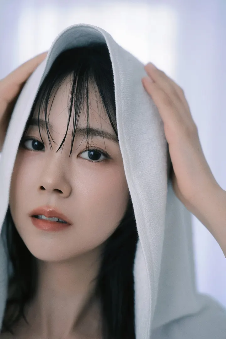 Close portrait of Han Seung Yeon (ハン・スンヨン) holding a pale towel over her head.