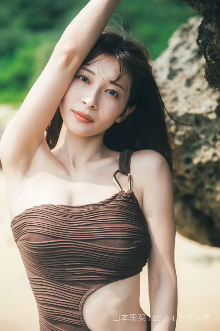 Rina Yamamoto (山本里菜) posing beside a tree in a brown cutout swimsuit with one arm raised, in an advance photograph from Rina, desu.
