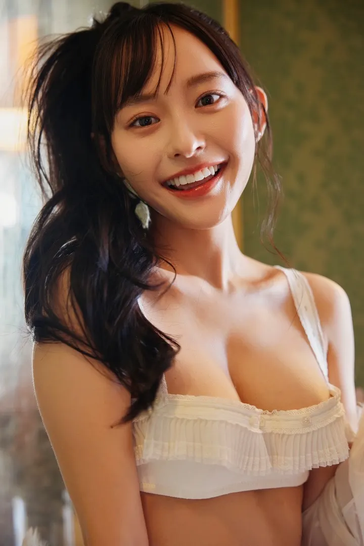 Kanami Takasaki smiling indoors in white ruffled lingerie, with her hair gathered to one side.