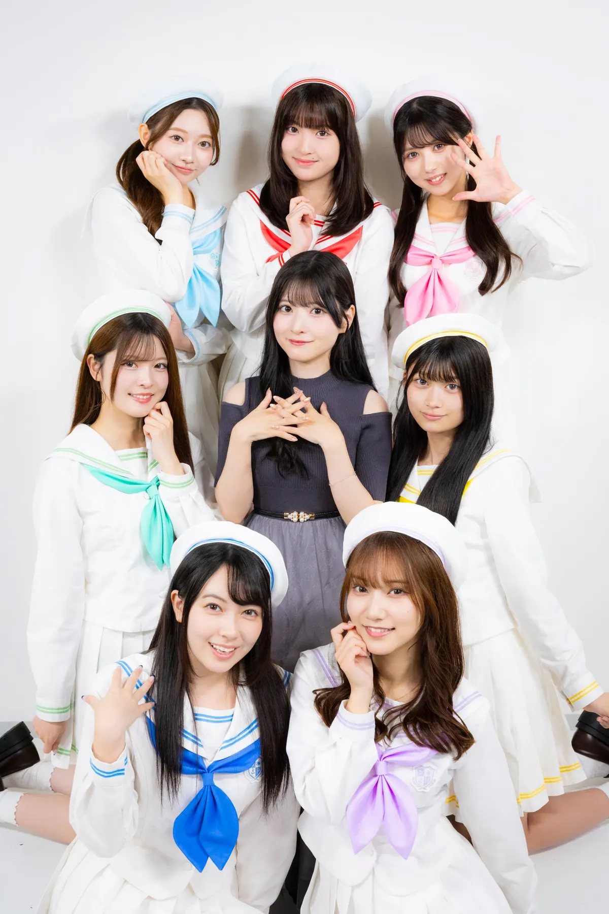 SUNNY PARADE’s seven members in white sailor-style outfits with colored bows, posing with producer Rui Takanashi against a white background.