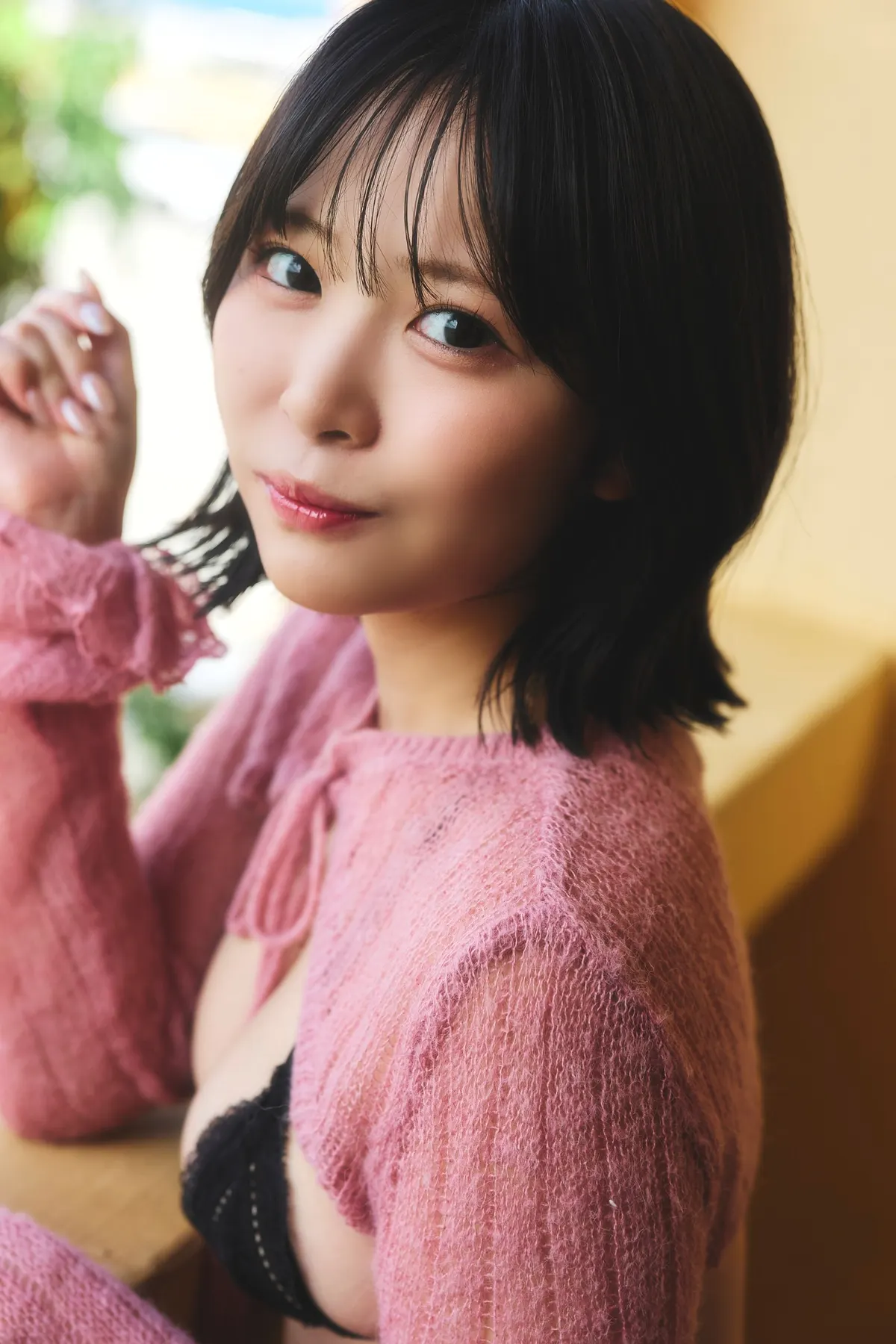 Yumeka Kimura (木村夢叶) looks toward the camera beside a window, wearing a pink knitted cardigan over black lingerie.